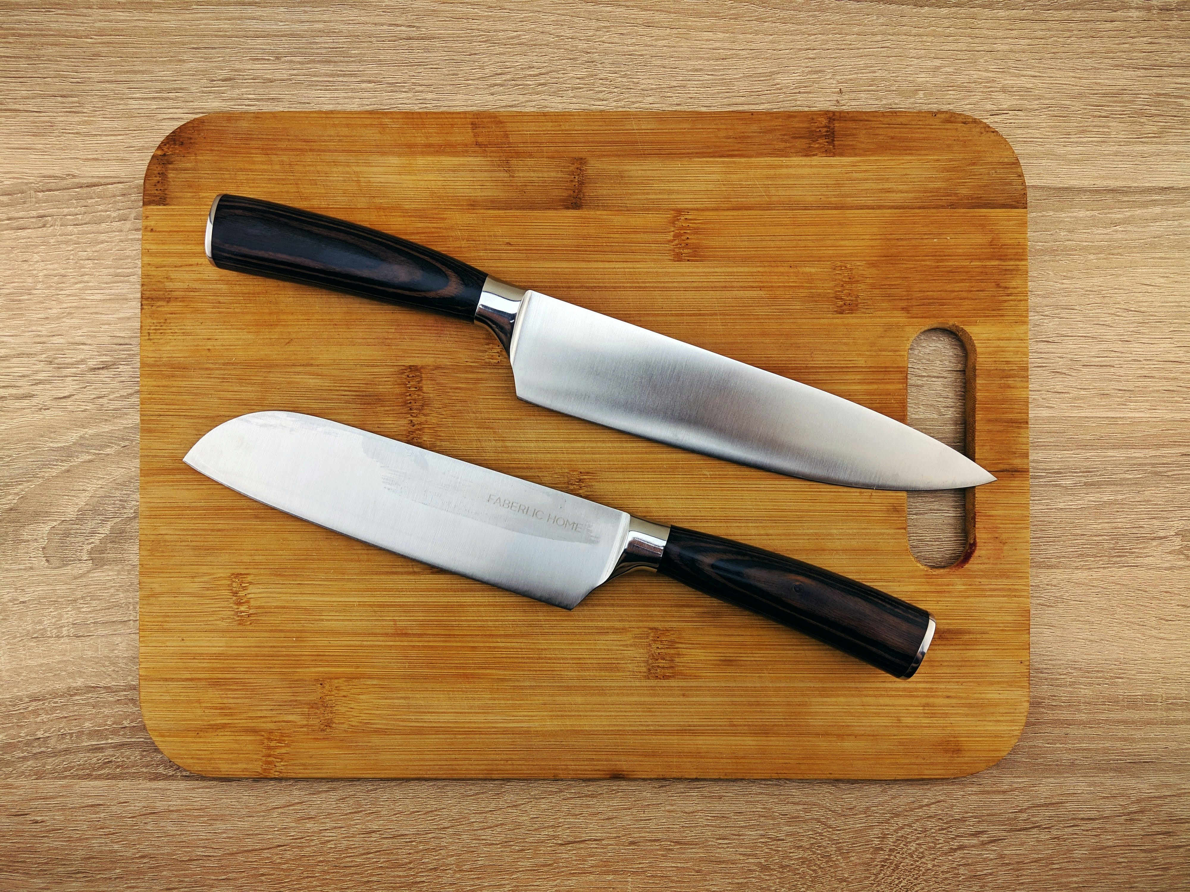 picture of two knives on a wood cutting board